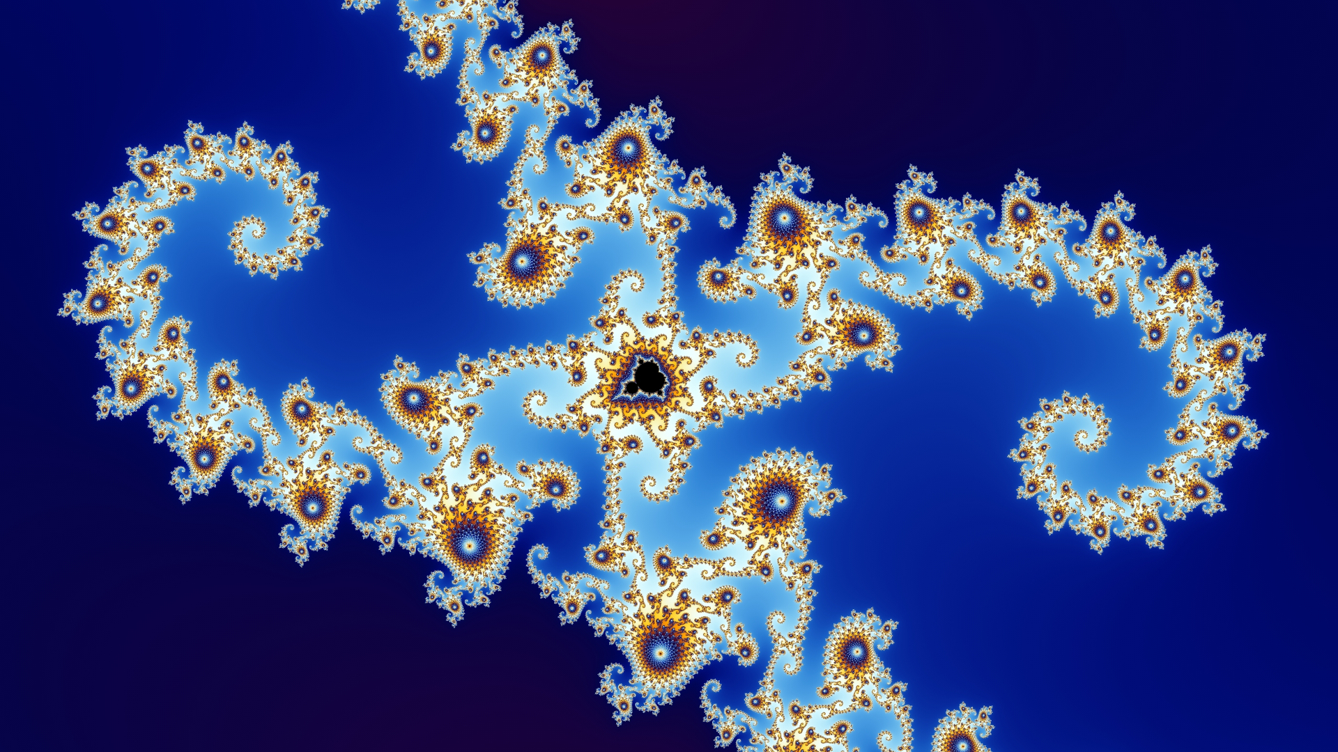 Intricate fractal spiral pattern showing a colorful detail of the Mandelbrot set in vibrant shades of blue, gold, and white against a deep blue gradient background.